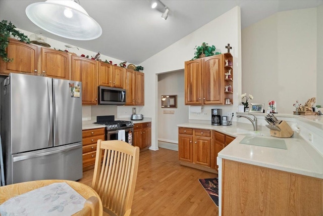 kitchen with open shelves, a sink, light wood finished floors, lofted ceiling, and stainless steel appliances