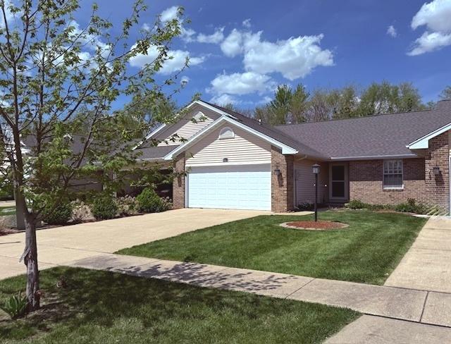 ranch-style home featuring brick siding, a garage, a front yard, and concrete driveway