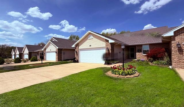 ranch-style home with an attached garage, driveway, a front lawn, and brick siding