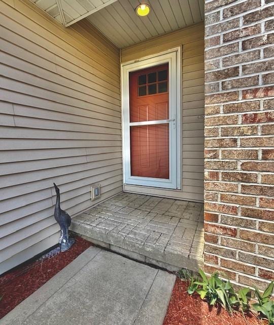 property entrance featuring brick siding