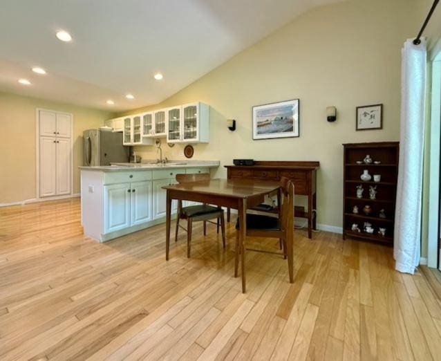 dining room with recessed lighting, baseboards, light wood-style flooring, and lofted ceiling