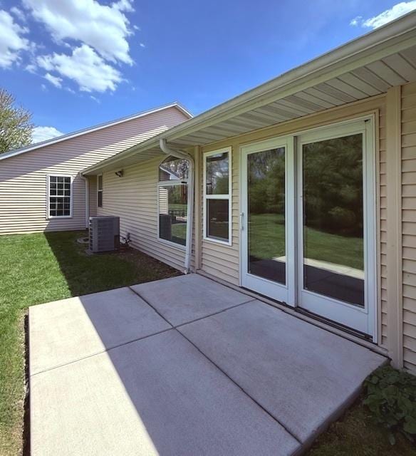 back of property featuring a lawn, central AC, and a patio area