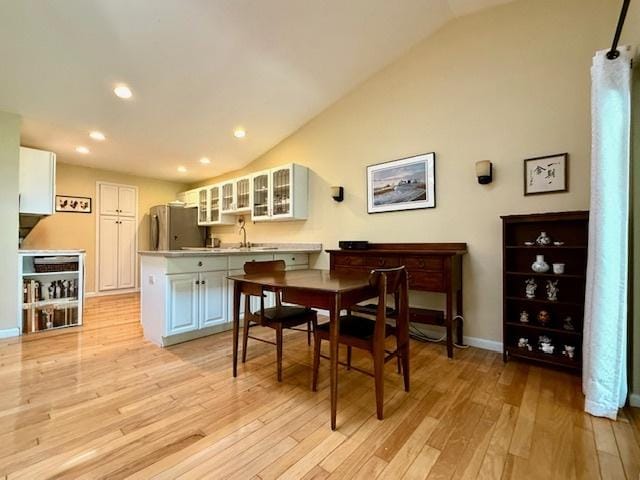 dining room featuring recessed lighting, baseboards, light wood-style flooring, and lofted ceiling