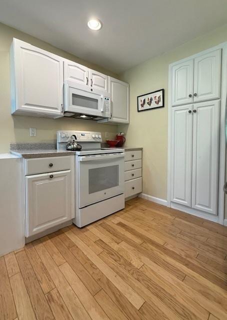kitchen featuring light wood-type flooring, recessed lighting, white cabinetry, and white appliances