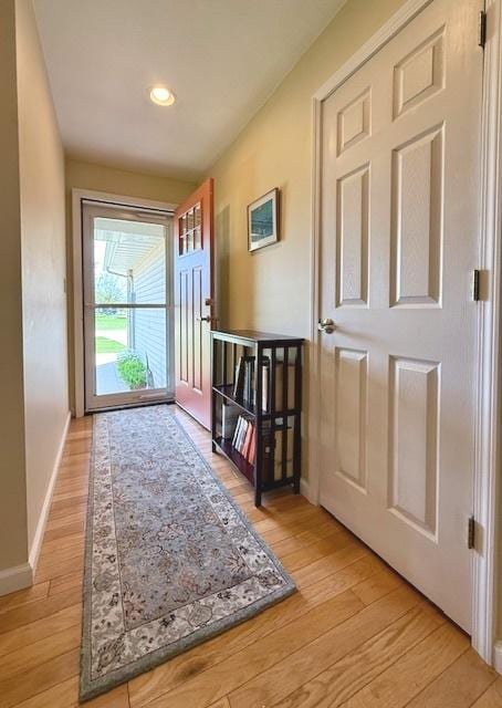 doorway featuring baseboards, recessed lighting, and light wood-style flooring