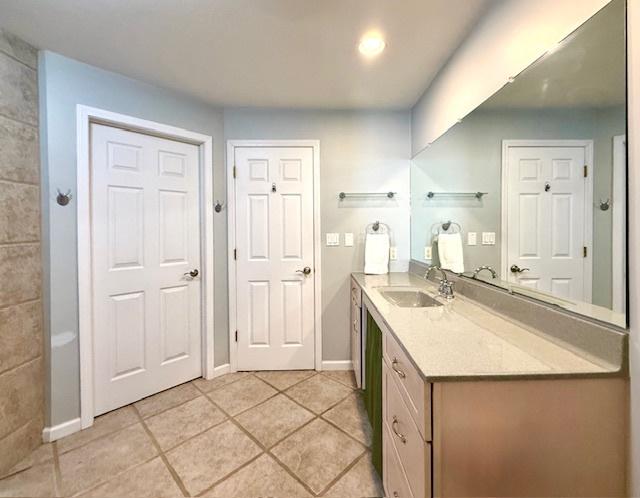 bathroom with tile patterned floors, baseboards, and vanity
