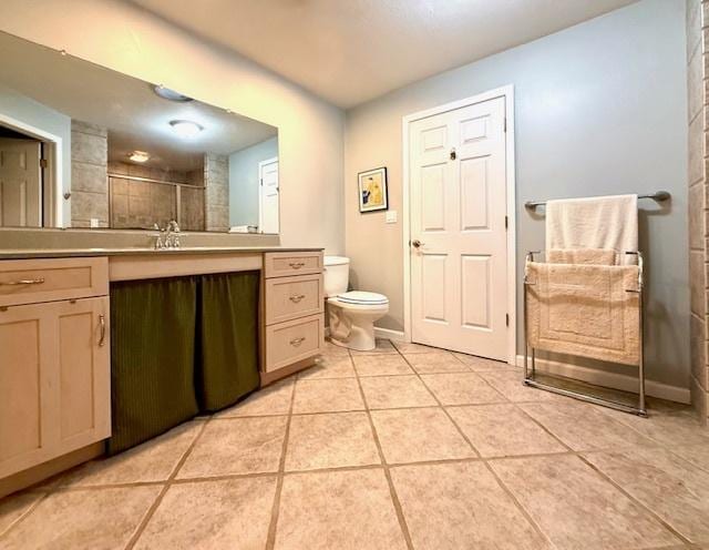 full bath with a tile shower, vanity, toilet, tile patterned floors, and baseboards