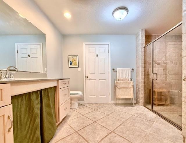 bathroom with toilet, a shower stall, tile patterned flooring, and vanity