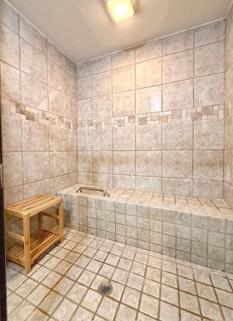bathroom featuring tile patterned flooring, tiled tub, a tile shower, and tile walls