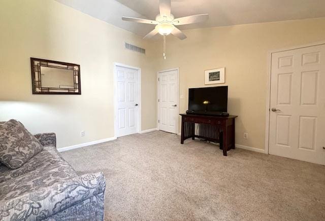 living room featuring ceiling fan, visible vents, baseboards, and carpet