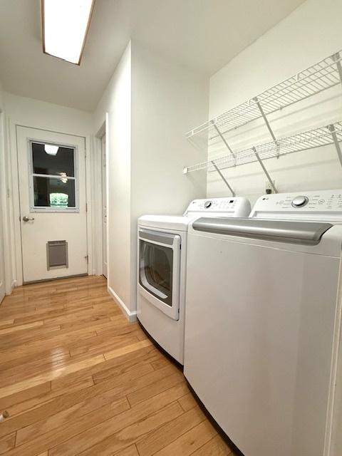 laundry room with separate washer and dryer, laundry area, and light wood finished floors