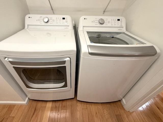 laundry area featuring laundry area, wood finished floors, and washing machine and dryer