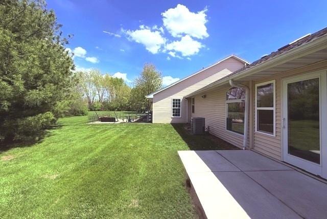 view of yard with central AC unit and a patio area