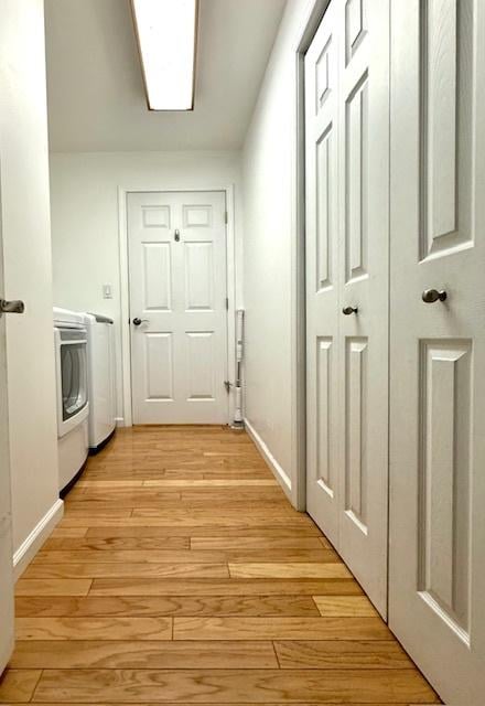 interior space featuring baseboards, light wood-type flooring, and washer and dryer