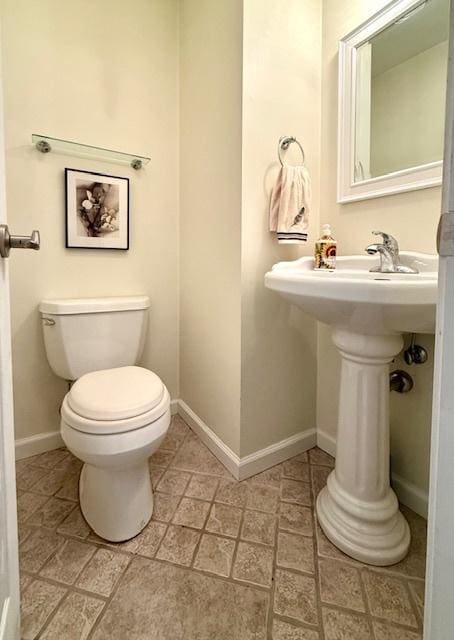 bathroom with baseboards and toilet