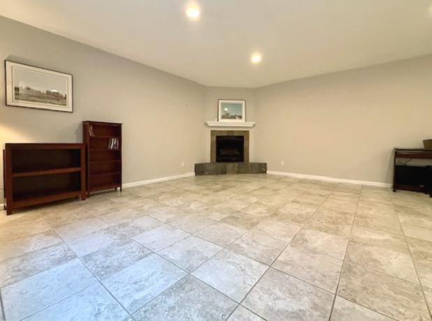unfurnished living room with recessed lighting, baseboards, a tiled fireplace, and light tile patterned floors