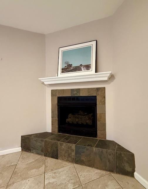 interior details with baseboards and a tile fireplace