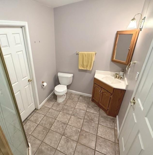 bathroom featuring baseboards, toilet, and vanity