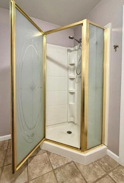 full bathroom with baseboards, a shower stall, and tile patterned floors