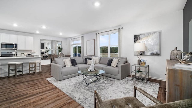 living area featuring dark wood-type flooring, recessed lighting, and baseboards