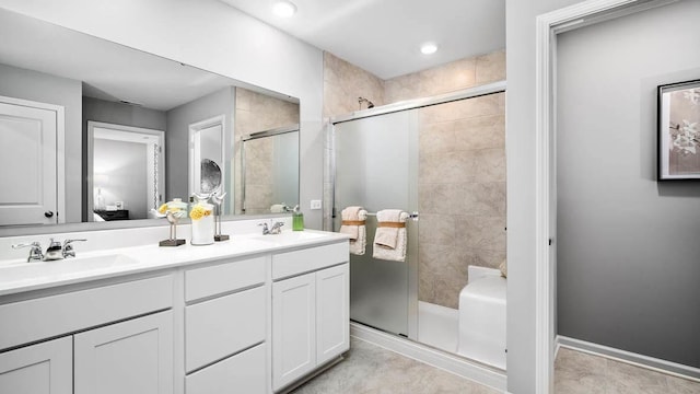 bathroom with double vanity, recessed lighting, a shower stall, and a sink