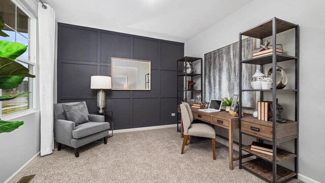 office featuring light colored carpet, a healthy amount of sunlight, and a decorative wall