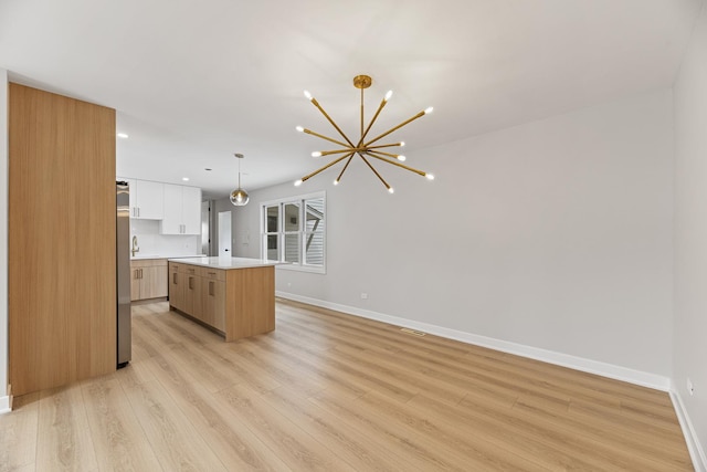 18624 W Pamela Pl, Gurnee, IL 60031 - kitchen featuring an inviting chandelier, light wood finished floors, light countertops, baseboards, and a kitchen island