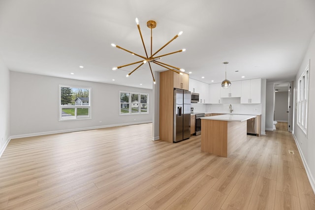 18624 W Pamela Pl, Gurnee, IL 60031 - kitchen featuring appliances with stainless steel finishes, a center island, light countertops, a notable chandelier, and open floor plan
