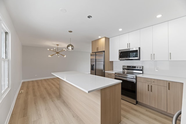 18624 W Pamela Pl, Gurnee, IL 60031 - kitchen with light wood-type flooring, appliances with stainless steel finishes, a notable chandelier, and a center island
