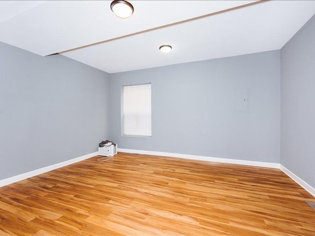 spare room with baseboards and light wood-style flooring