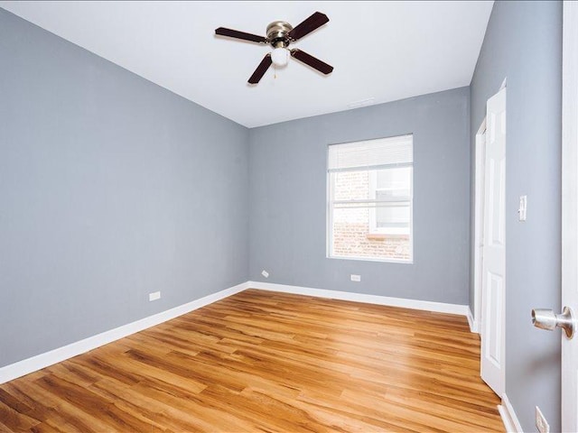 empty room featuring ceiling fan, baseboards, and light wood-style floors