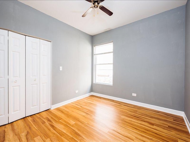 unfurnished bedroom with baseboards, a ceiling fan, light wood-style flooring, and a closet