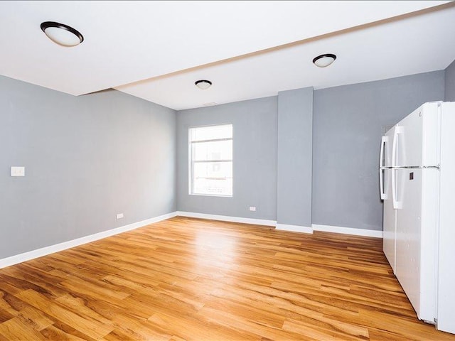 empty room featuring light wood-type flooring and baseboards