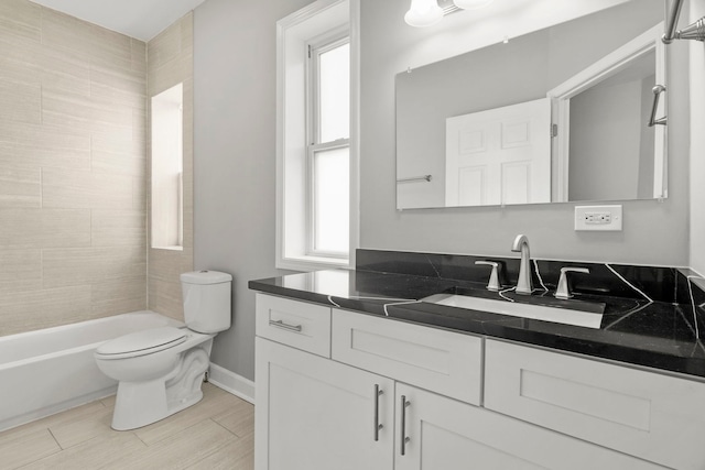 full bath featuring vanity, baseboards, a healthy amount of sunlight, and toilet
