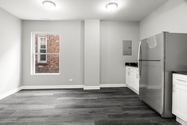 kitchen featuring freestanding refrigerator, white cabinets, electric panel, and dark countertops