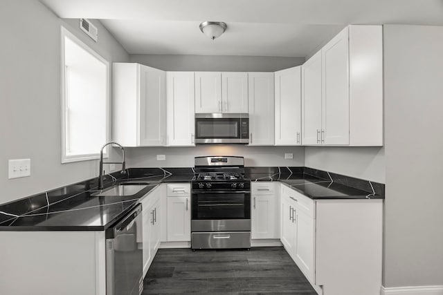 kitchen with visible vents, a sink, white cabinetry, and appliances with stainless steel finishes