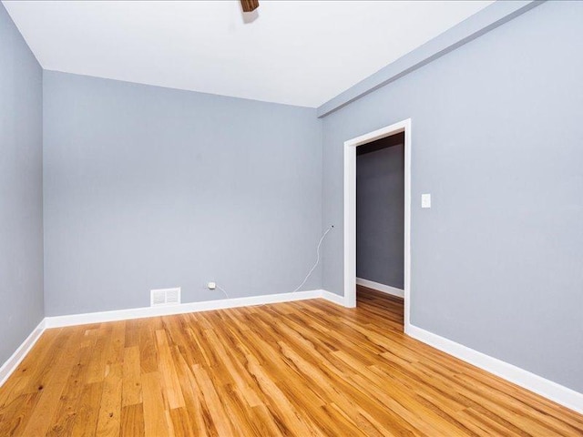 empty room with baseboards, visible vents, and light wood-style floors