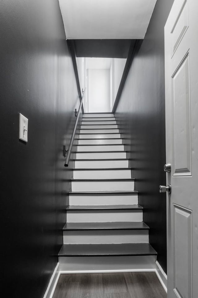 stairway featuring baseboards and wood finished floors