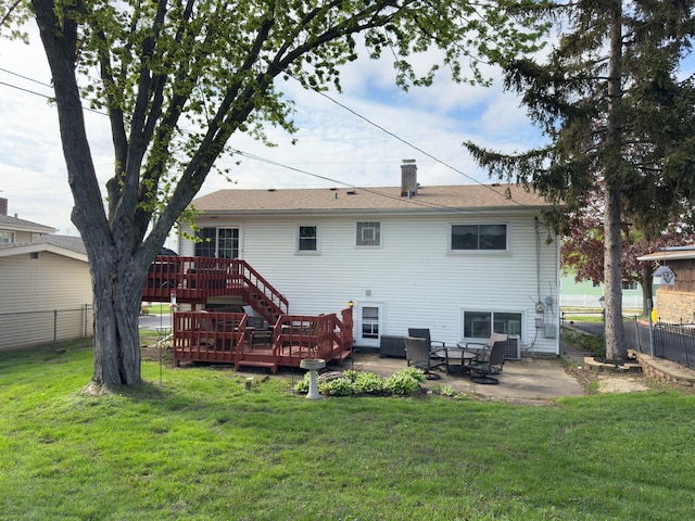back of property featuring a lawn, fence, a patio area, and a deck