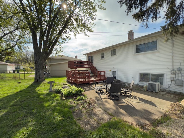 back of house featuring central AC, a deck, fence, a yard, and a patio area