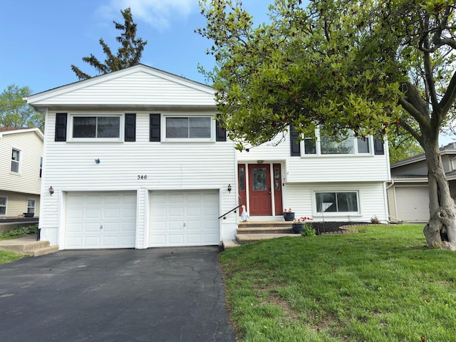 raised ranch with a front lawn, entry steps, aphalt driveway, and a garage