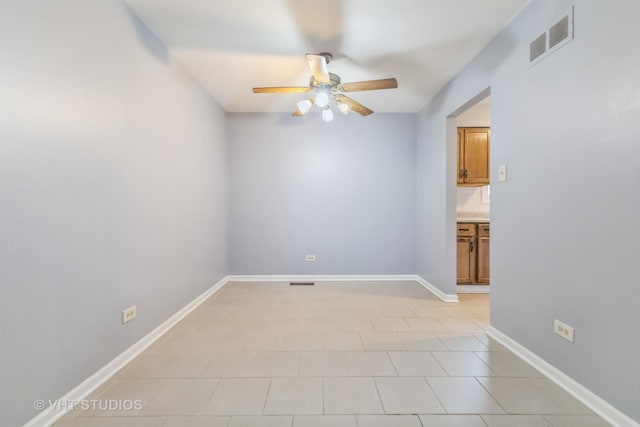 spare room featuring ceiling fan and light tile patterned floors
