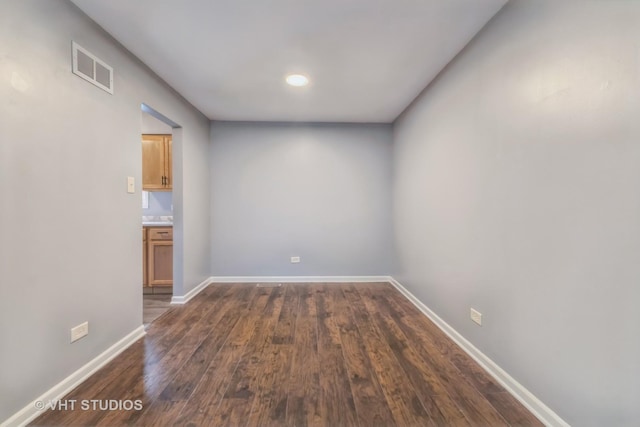 spare room with dark wood finished floors and baseboards