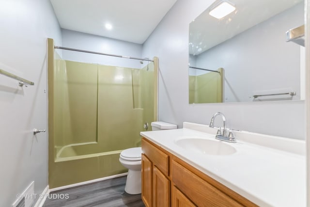 bathroom with wood finished floors, vanity, and  shower combination