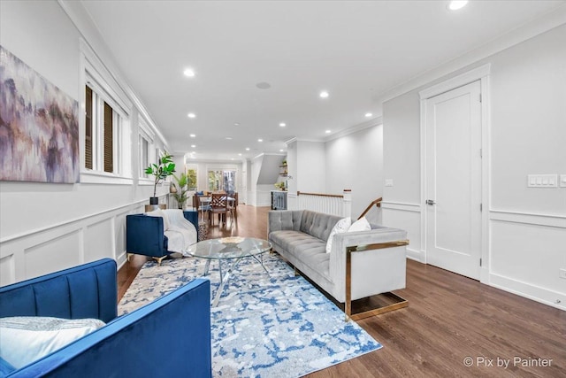 living room featuring ornamental molding, a decorative wall, recessed lighting, and wood finished floors