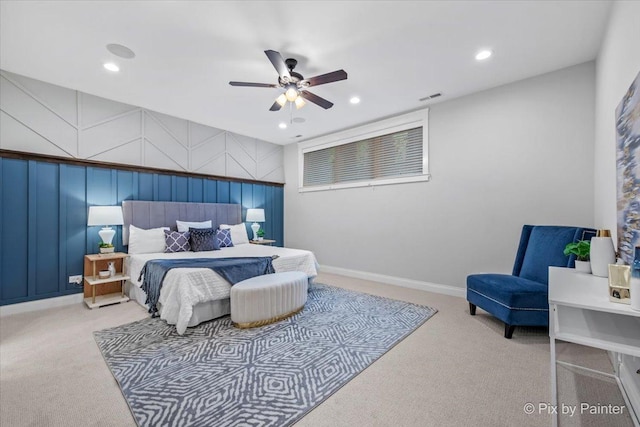 carpeted bedroom featuring a decorative wall, recessed lighting, a ceiling fan, baseboards, and visible vents