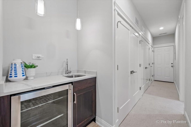bar with a sink, baseboards, wet bar, wine cooler, and visible vents