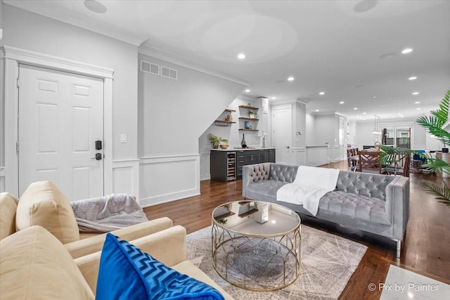 living area featuring ornamental molding, recessed lighting, wood finished floors, and visible vents