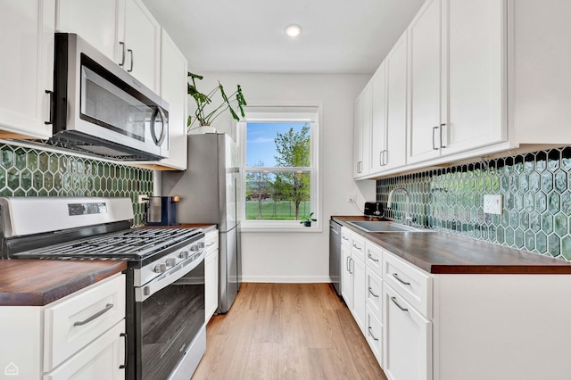 6102 S Kimbark Ave Unit 1W, Chicago, IL 60637 - kitchen with wooden counters, backsplash, light wood-type flooring, a sink, and stainless steel appliances