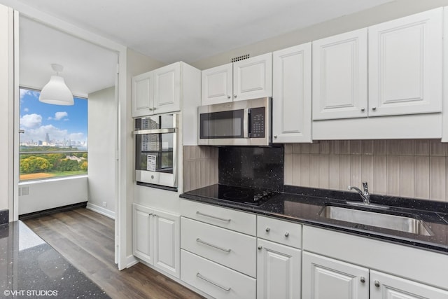 4800 S Chicago Beach Dr Unit 1005N, Chicago, IL 60615 - kitchen with decorative backsplash, white cabinetry, stainless steel microwave, and dark stone counters